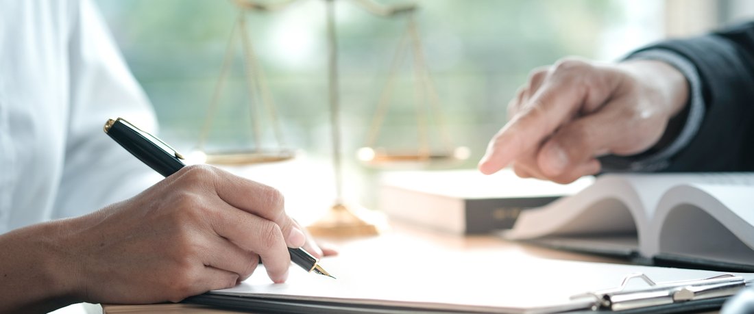 Médiation-de-consommation Deux personnes signent un document