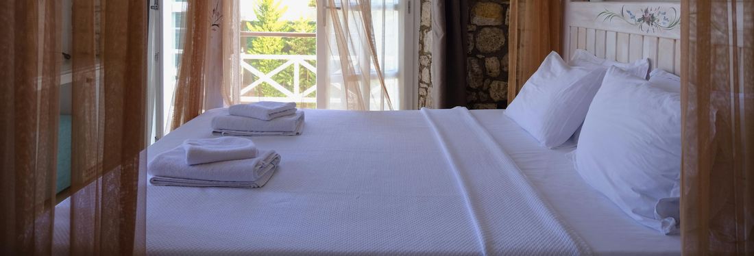 Crédit photo : hello aesthe de Pexels Lit double dans une chambre d'hôtel avec fenêtre ouverte donnant sur l'extérieur