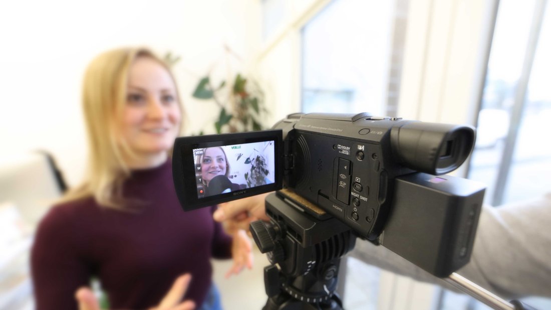 camera-interview-communication.jpg A woman speaks in front of a camera that is filming.