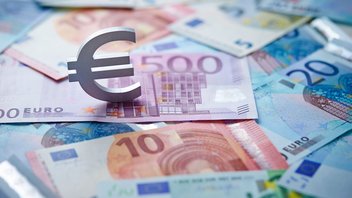 Le sigle euro posé sur un tas de billets en euros