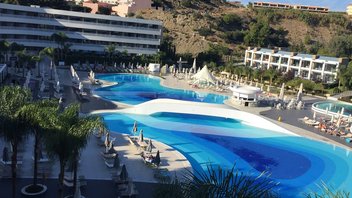 hôtel-avec-piscine Complexe hôtelier comportant une piscine extérieure avec transat et palmier