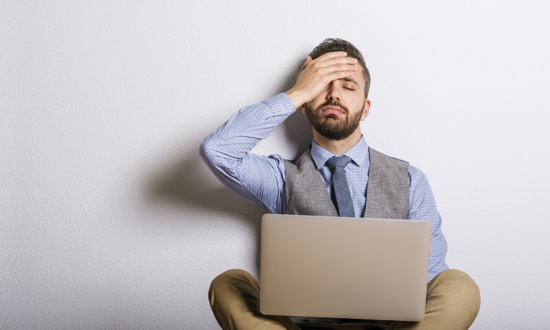 homme-ordinateur.jpg Un homme assis avec son ordinateur portable sur les genoux tient sa tête avec sa main.