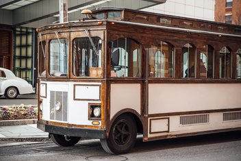 An old-fashioned city bus drives down the street