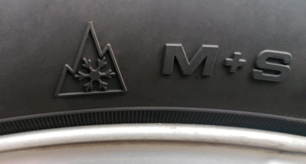 Close-up of the alpine symbol followed by the letters M+S on a car tyre