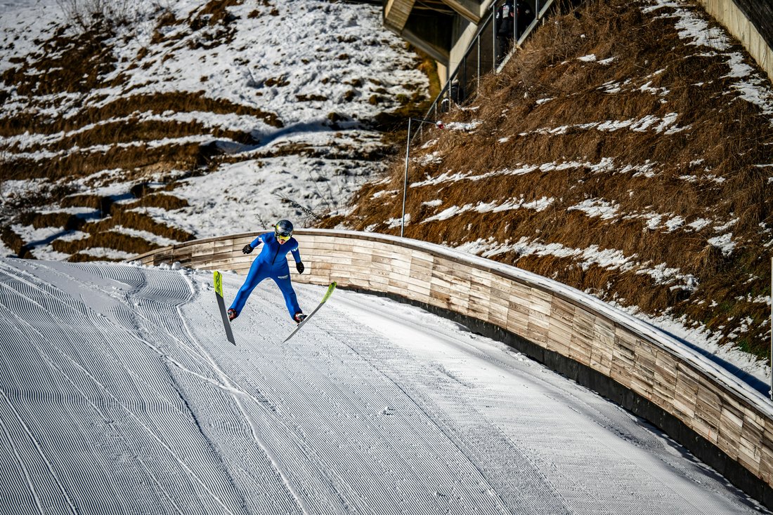 Un skieur en plein saut sur la piste