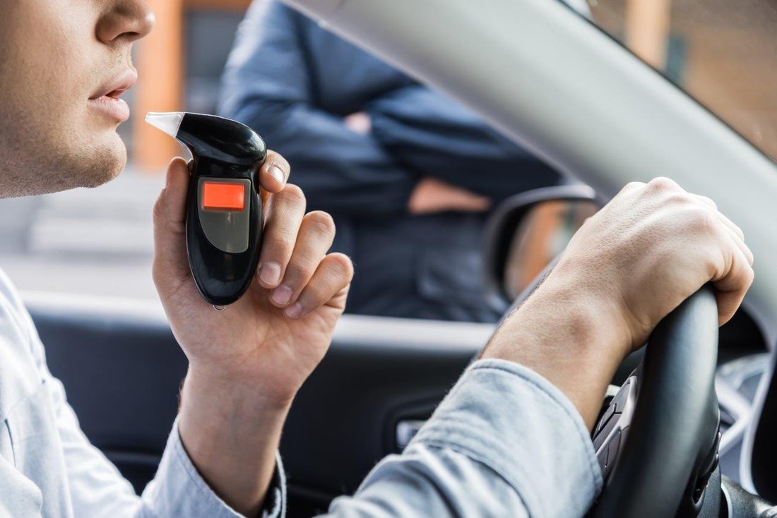 Contrôle_ethylotest_voiture_police A man blows into a breathalyser while driving his car