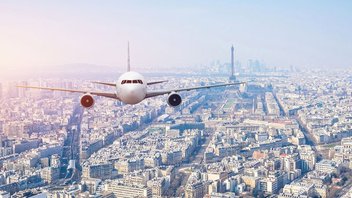 Un avion survole Paris, avec la Tour Eiffel en arrière-plan
