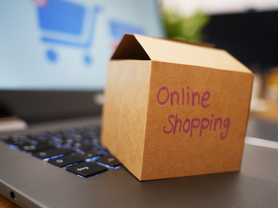 A box labeled “Online shopping” placed on a laptop computer that is turned on