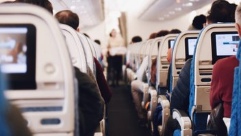 Une rangée de sièges dans un avion, les passagers sont assis et vus de dos