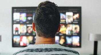 man-television-streaming.jpg A man, seen from behind looking at a TV screen.