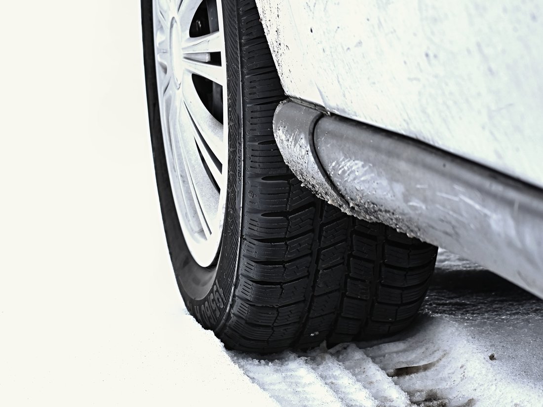 Un gros plan sur le pneu d'une voiture dans la neige.