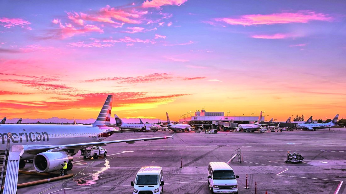 aeroport-avions-vols-transport.jpg Vue sur la piste d'atterrissage d'un aéroport avec de nombreux avions et véhicules.