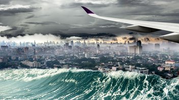 Catastrophes naturelles L'aile d'un avion survole une vague d'un tsunami qui déferle sur la ville